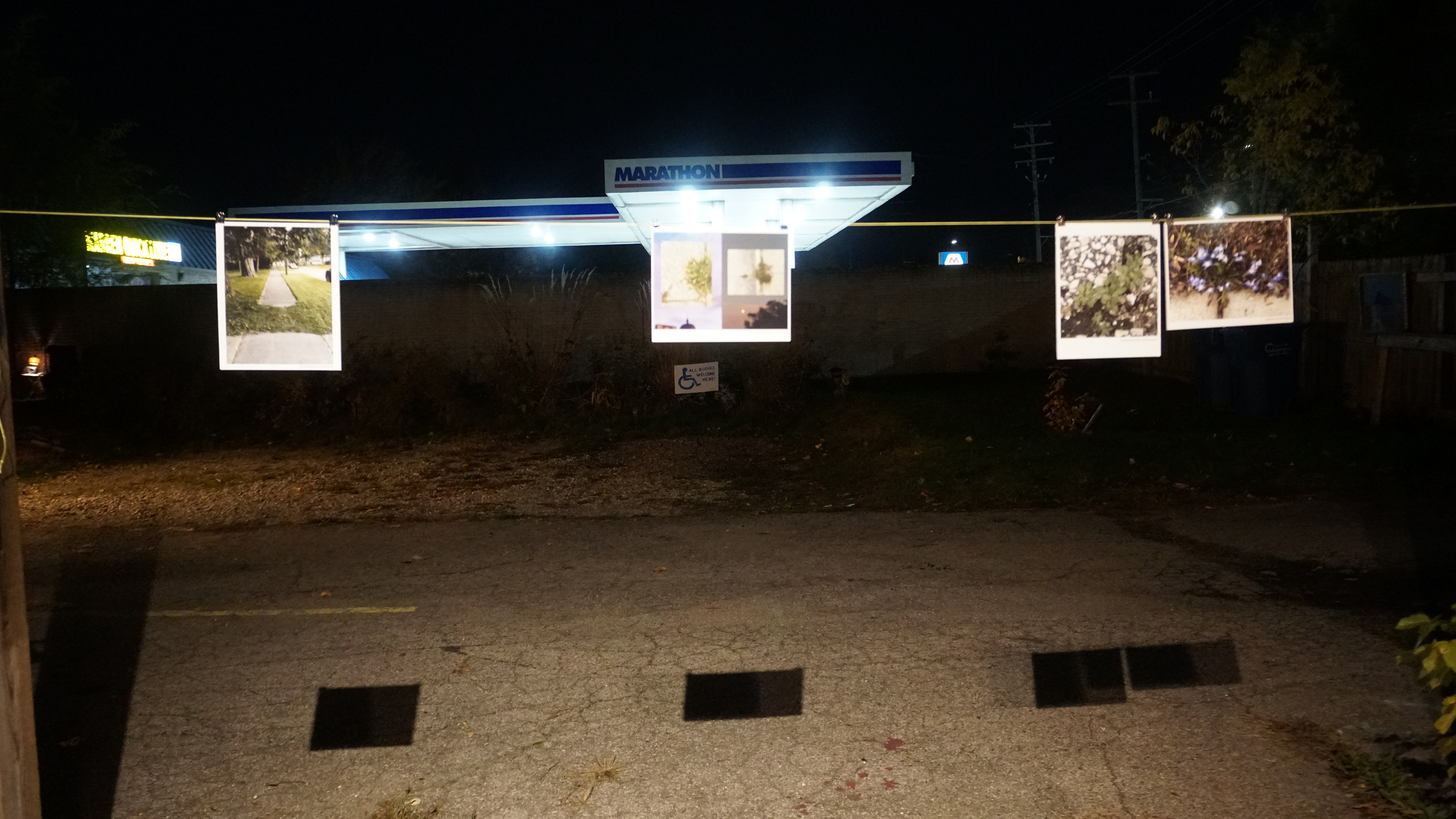 Exhibition view with gas station in background