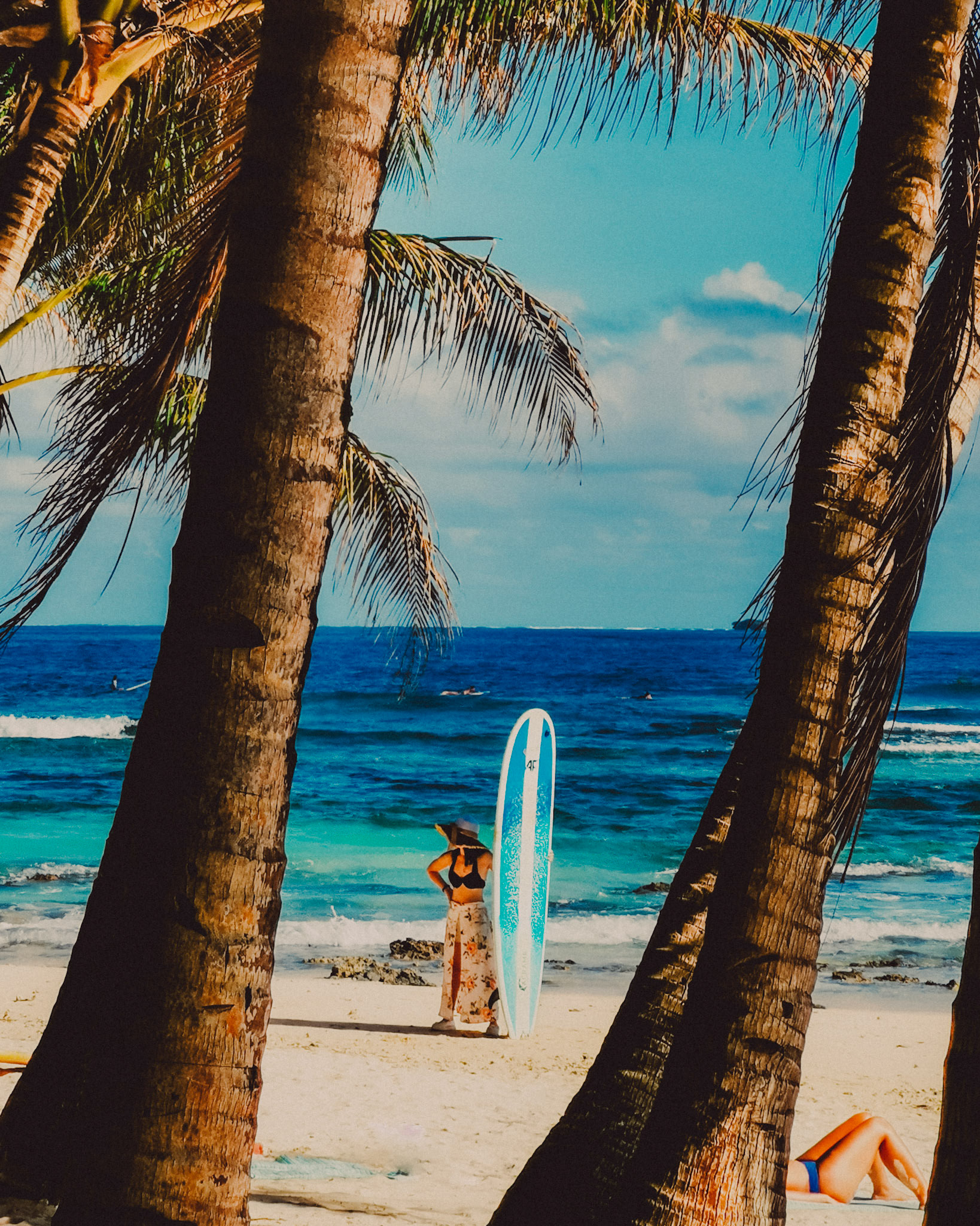 An asian girl holding a surfboard, framed in between two palm trees, Jacking Horse, Siargao Island, Philippines, March 2019, Huawei Mate 20 Pro.