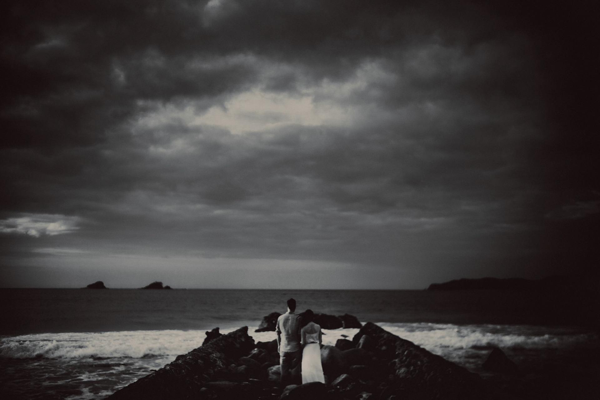 Moody black and white engagement portraits in front of crashing waves in Nacpan Beach, El Nido, Palawan, Philippines, Southeast Asia, January 2017, Leica M