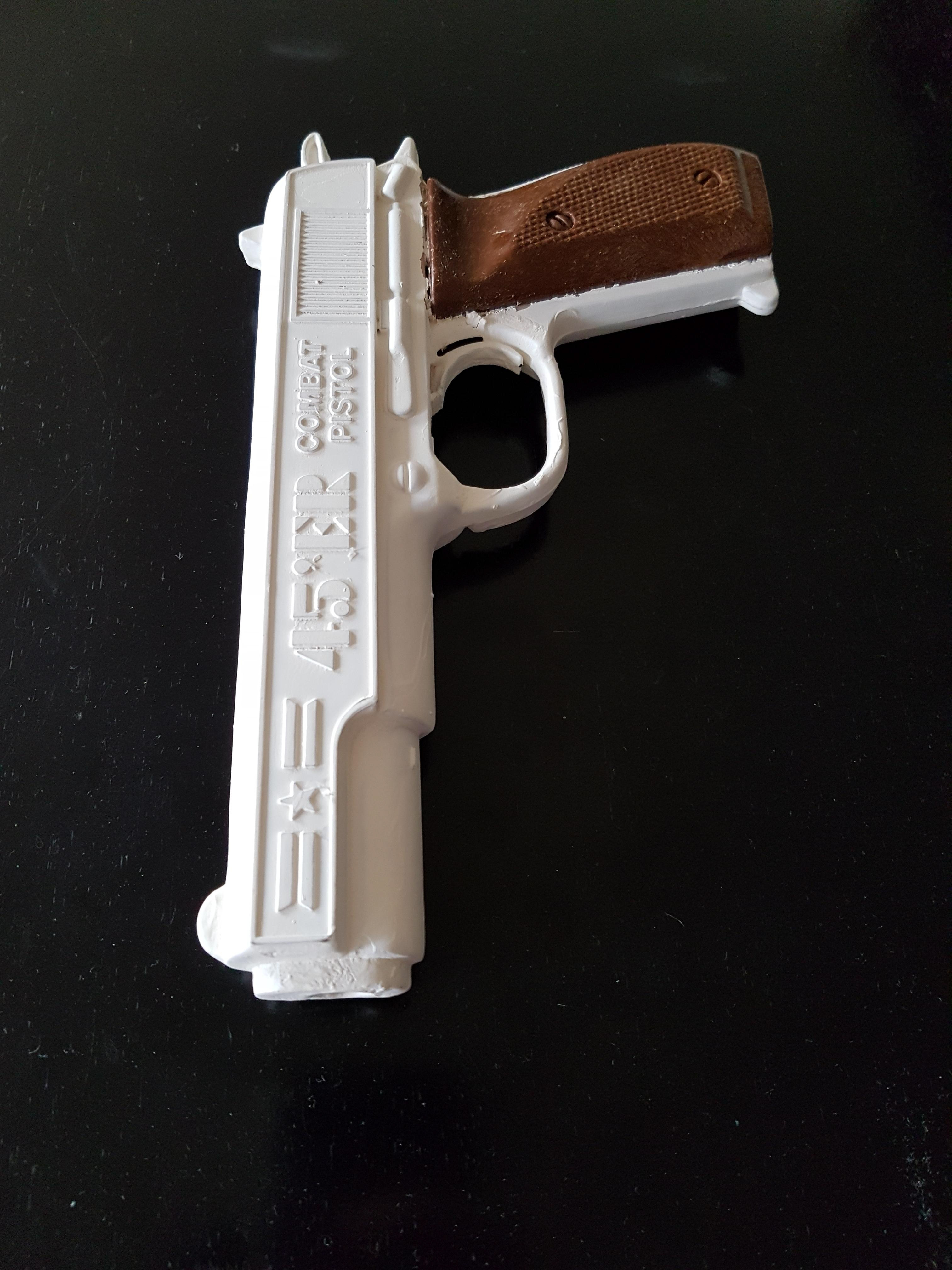 A realistic plastic toy handgun painted white.