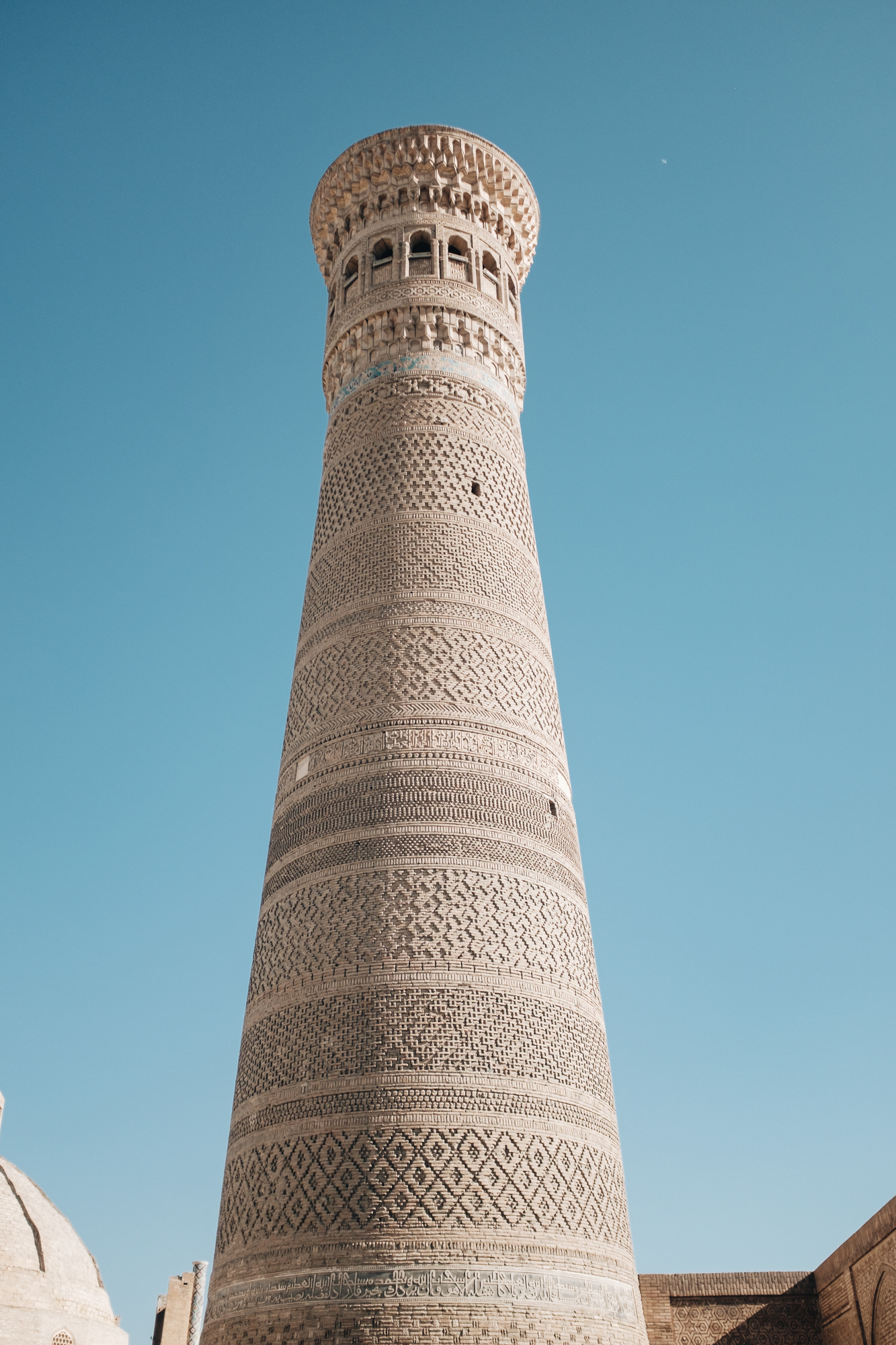 Kalon Minaret مناره کلان - minaret z 12. st. okouzlil i Čingischána, který se rozhodl ho zachovat, 47 m vysoký, ve své době nejvyšší budova ve střední Asii, poprvé zde byly použity modré kachlíky, které se poté za vlády Timura dostaly do celé střední Asie, na J a V straně jsou světlejší zrestaurované plochy, které byly poškozeny dělostřelectvem bolševického generála při dobývání města v r. 1920