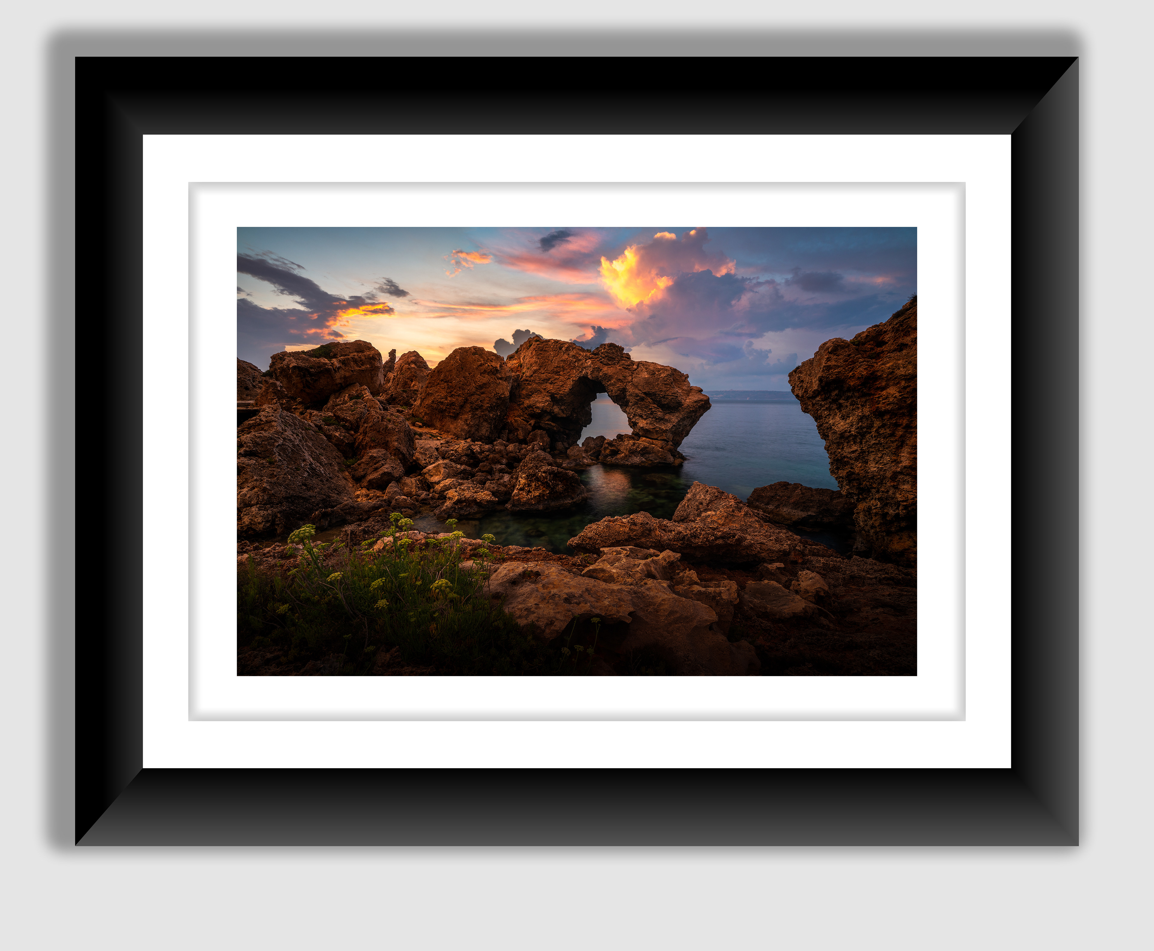 A beautiful fine art print of ta qassisu natural window with gozo in the background taken during a beautiful sunset .