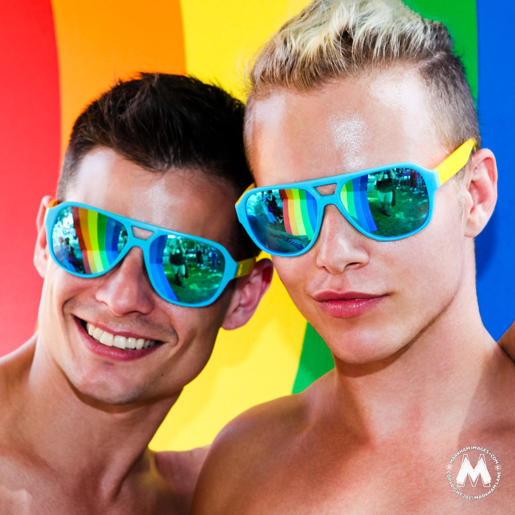 Two gays guys wearing reflective sunglasses, captured by photographer Markham Lane inside the rainbow-coloured Twitter activation, at the 2016 Sydney Gay and Lesbian Mardi Gras Fair Day held at Victoria Park.