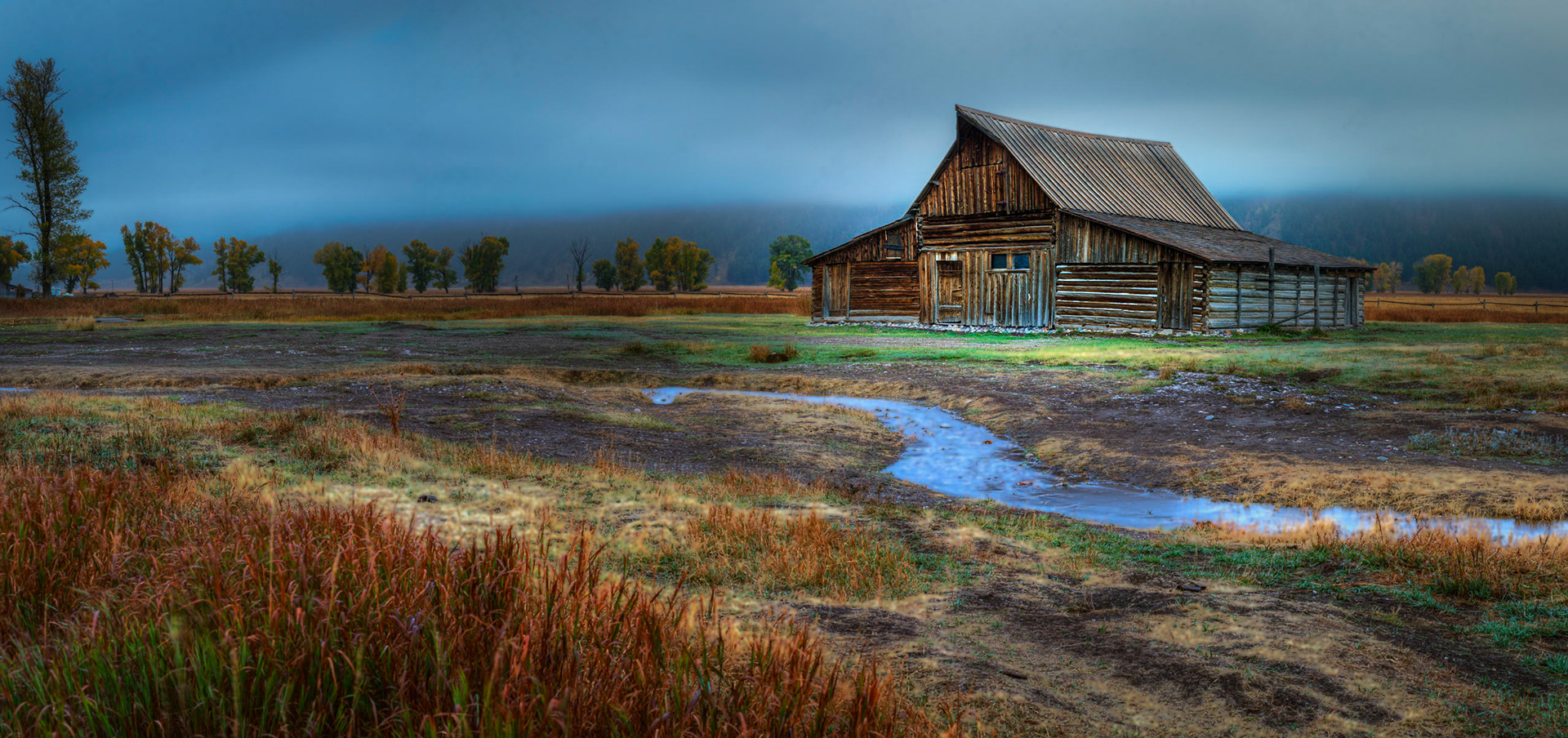 A foggy autumn dawn in Jackson Hole, along Mormon Row.Grand Teton National ParkWyomingSeptember 30, 2016This is an HDR panoramic image consisting of 6 frames comprised of 3 exposures each. HDR processing performed in Photomatix Pro.  Panoramic stitching performed in Photoshop. Additional processing performed in Lightroom and Photoshop.PENTAX K-1, TAMRON 28-300mm F3.5-6.3 Ultra zoom XRISO 100 53 mm  15.0 sec at ƒ / 11
