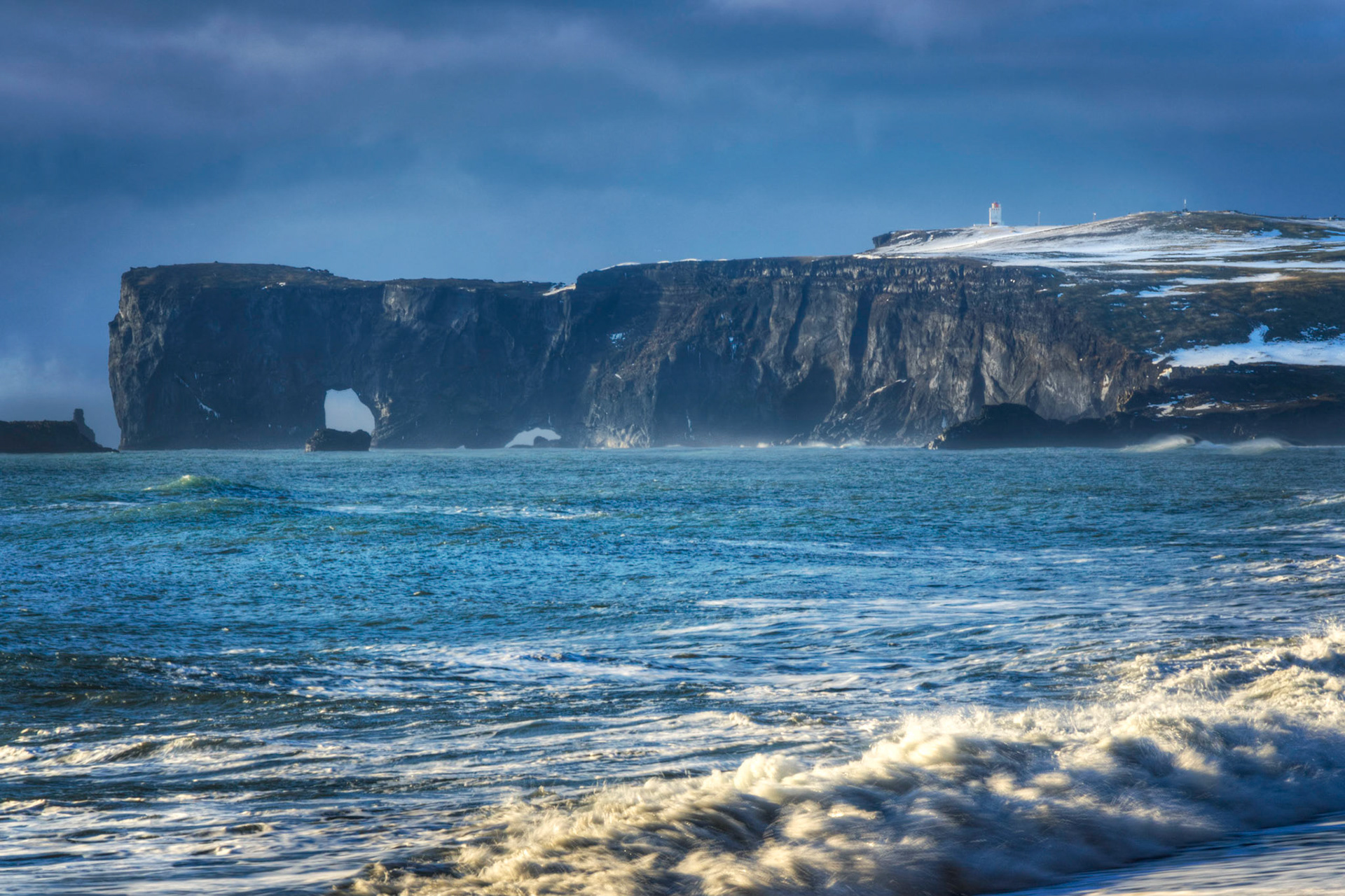 The lighthouse and sea arches at the peninsula of Dyhrólaey.Suðerland, IcelandFebruary 11, 2016This is an HDR image consisting of 5 exposures merged in Photomatix Pro. Additional processing in Lightroom and Photoshop.PENTAX K-3, Sigma 18-250mm f/3.5-6.3 DC OS HSMISO 100 120 mm  ⅕ sec at ƒ / 18