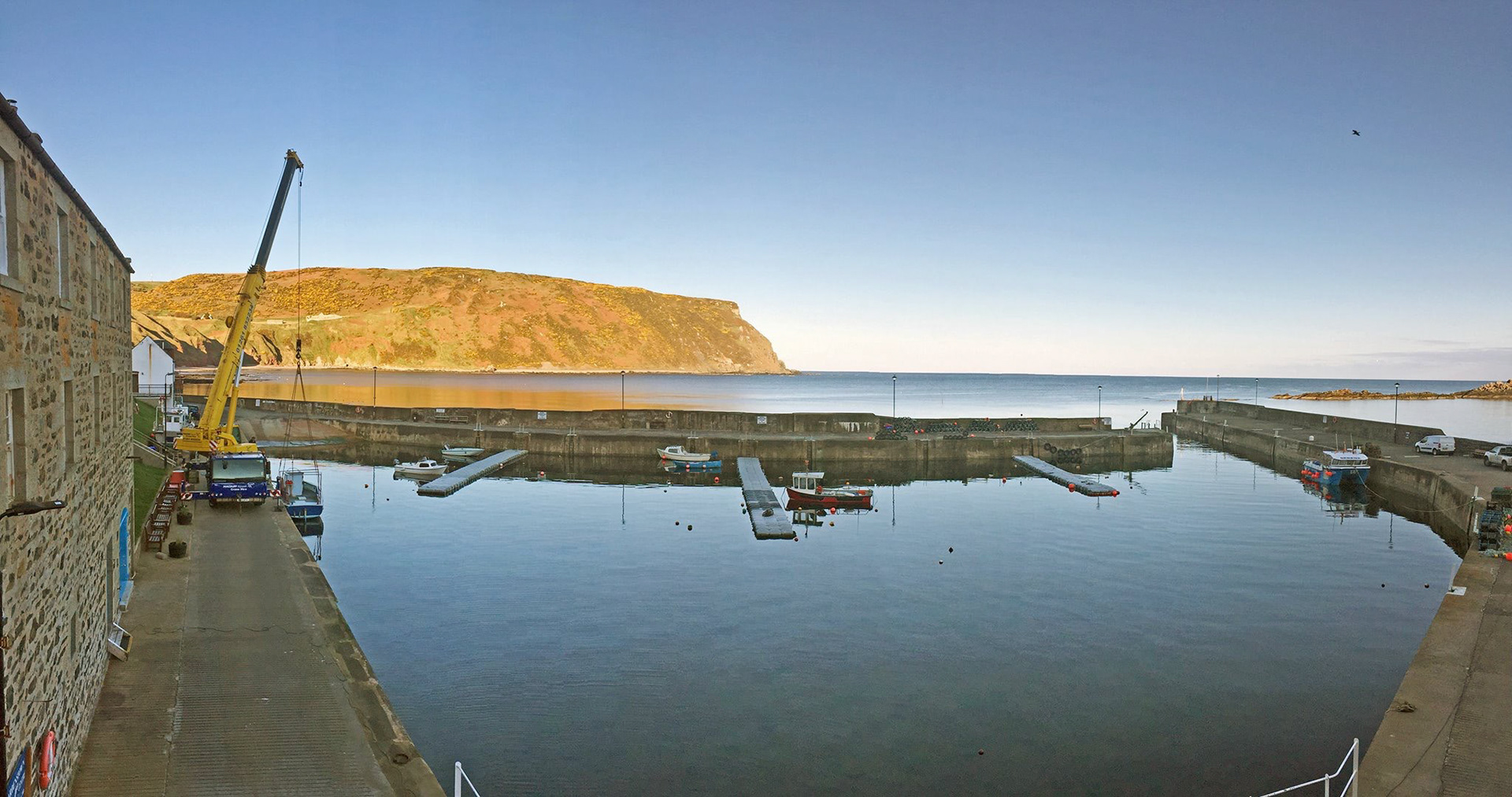 View from the balcony: an April morning watching a fishing boat being lowered back into the water after the winter break