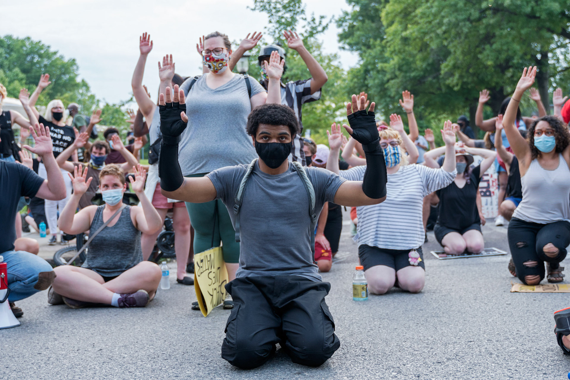 A man kneels in an intersection during a protest in the Central West End on Friday, July 3, 2020.