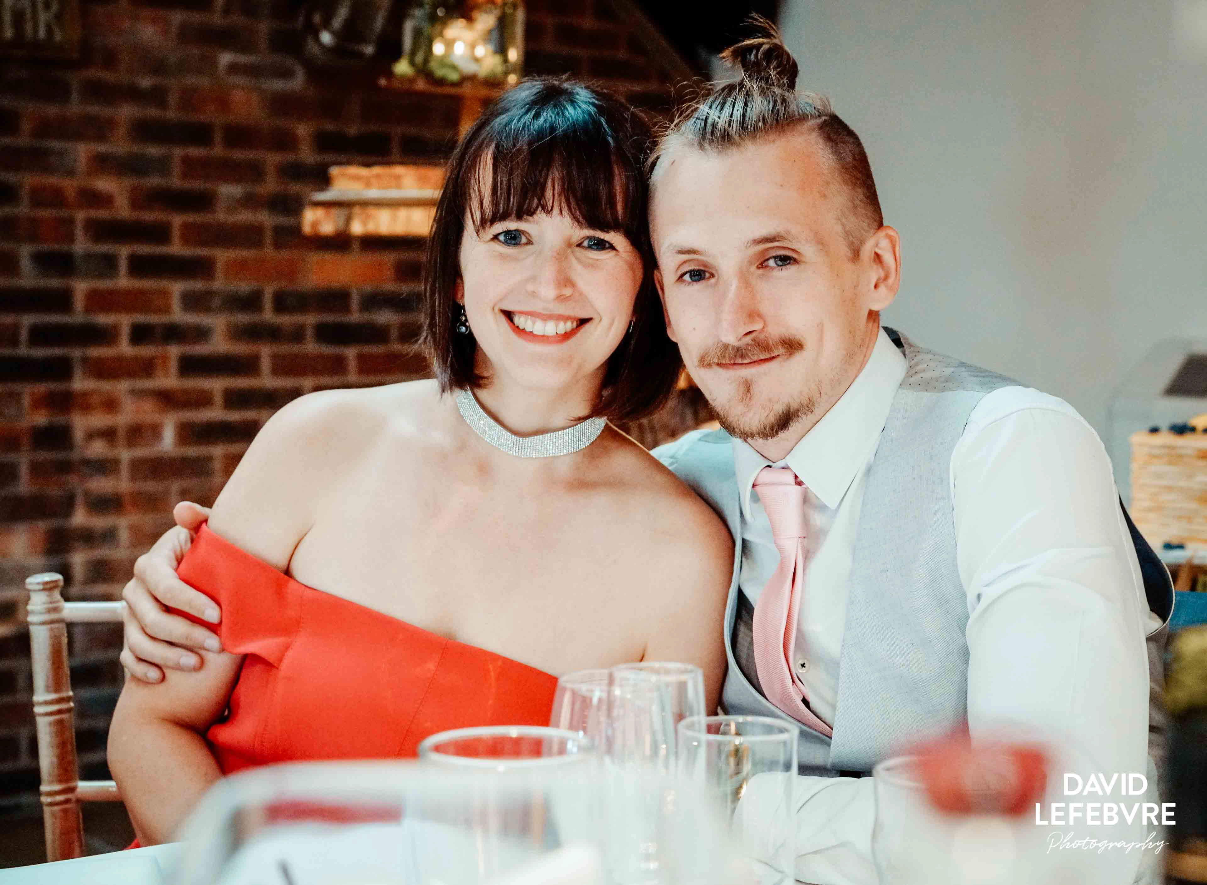 couple at wedding table smiling at owen barn house wedding venue