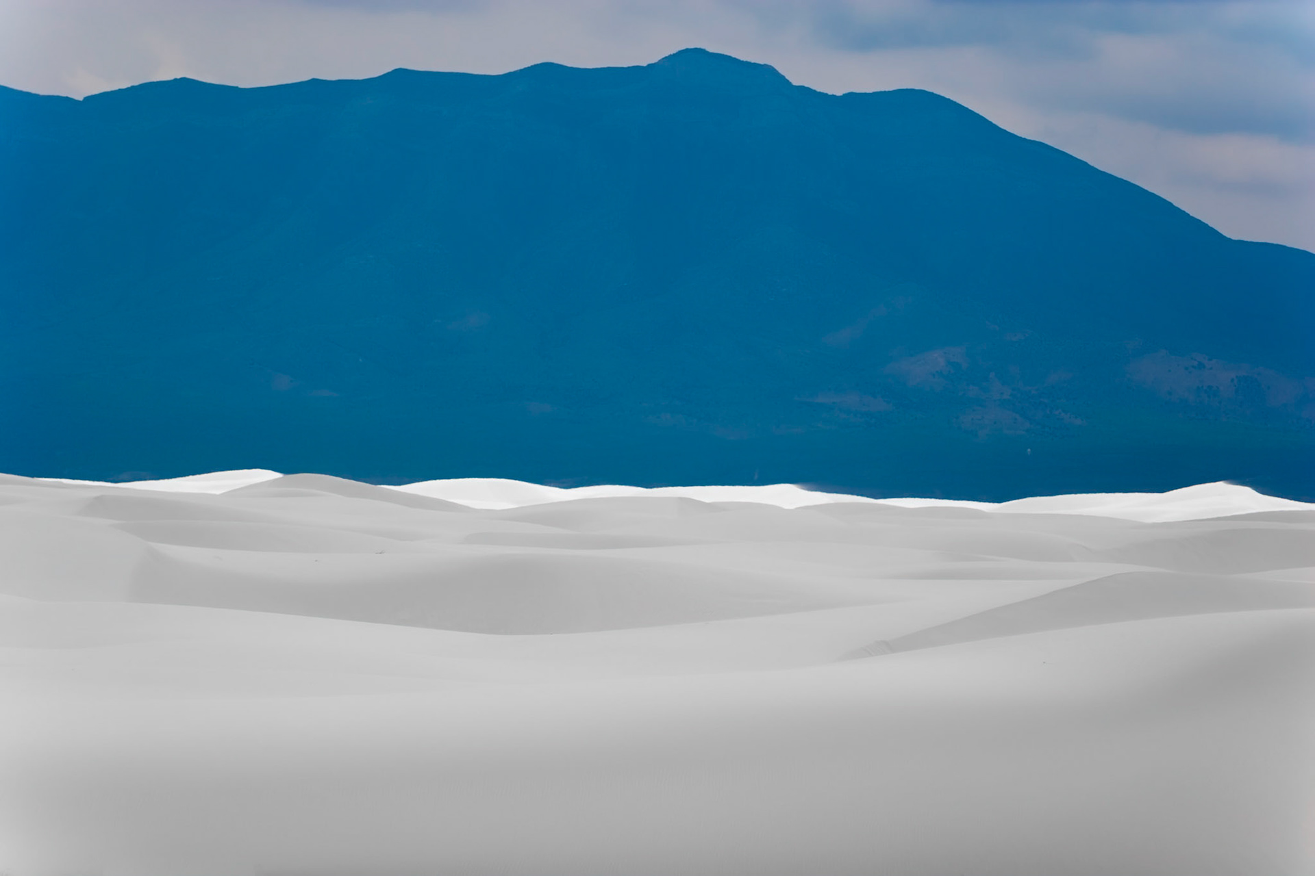 White Sands National Monument, New Mexico. Rising from the heart of the Tularosa Basin is one of the world's great natural wonders - the glistening white sands of New Mexico. Great wave-like dunes of gypsum sand have engulfed 275 square miles of desert, creating the world's largest gypsum dunefield. White Sands National Monument preserves a major portion of this unique dunefield, along with the plants and animals that live here.