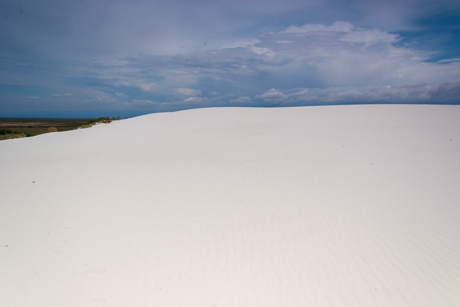 White Sands National Monument, New Mexico. Rising from the heart of the Tularosa Basin is one of the world's great natural wonders - the glistening white sands of New Mexico. Great wave-like dunes of gypsum sand have engulfed 275 square miles of desert, creating the world's largest gypsum dunefield. White Sands National Monument preserves a major portion of this unique dunefield, along with the plants and animals that live here.