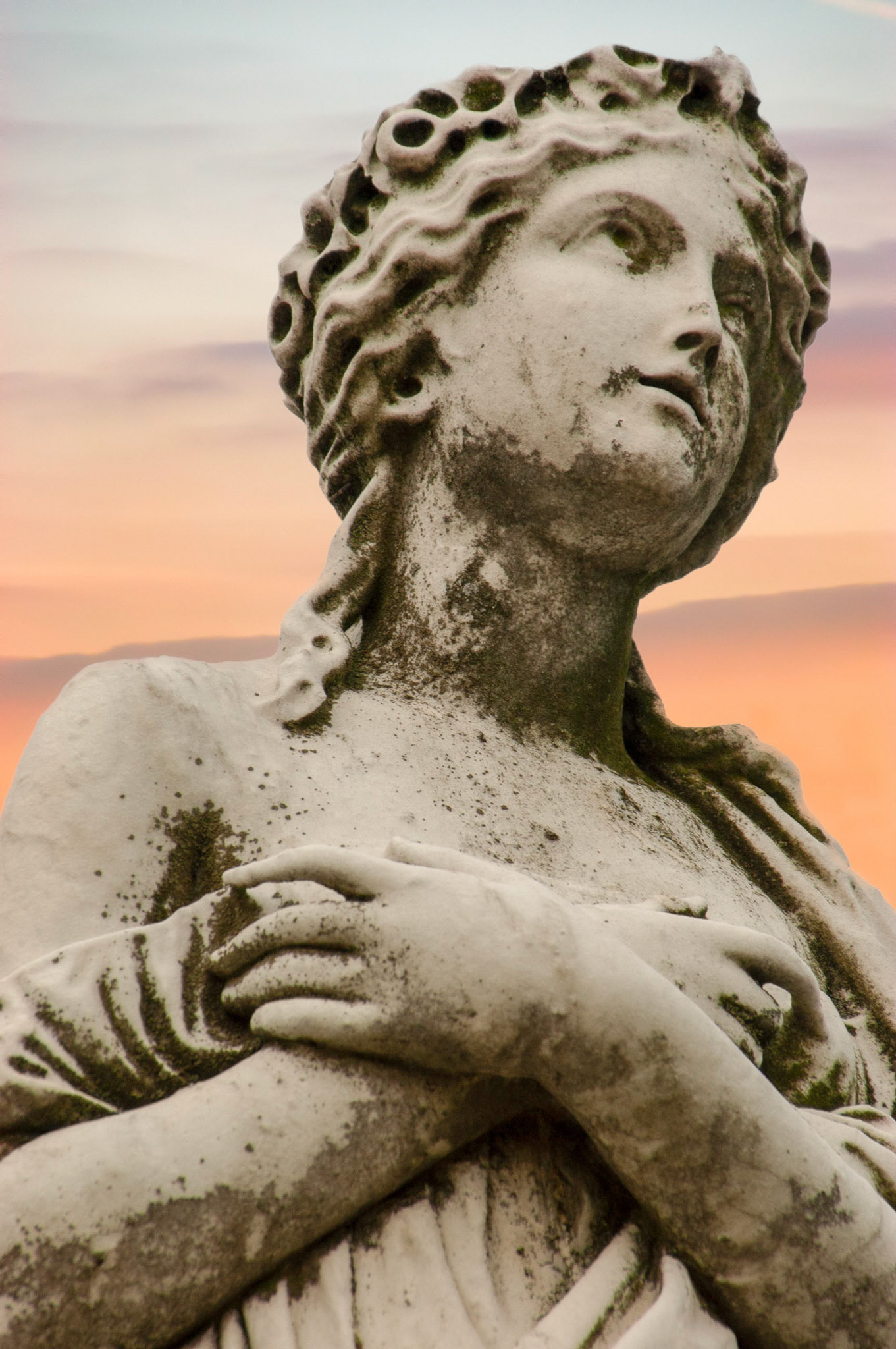 This statue of a woman with crossed hands is on one of the many grave markers at the Arlington National Cemetery in Arlington Virginia.