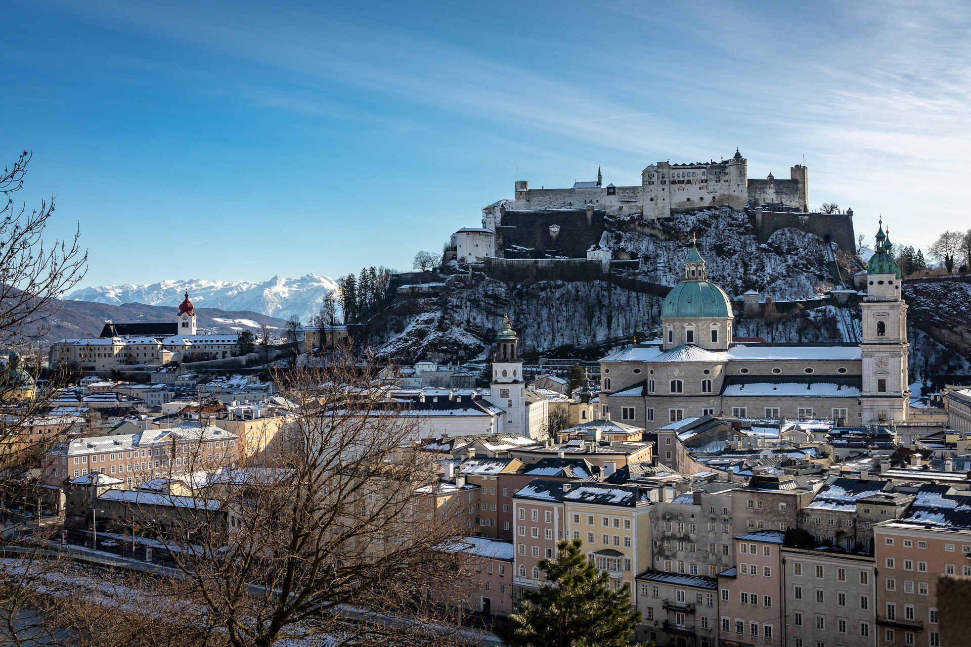 In the background Castle Hohensalzburg, in the foreground Salzburg Cathedral with the characteristic green dome
