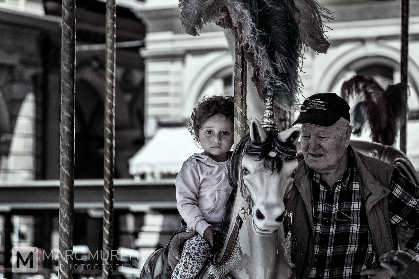 De-Saturated Little Tuscan Girl on a Hobby Horse of a Merry-Go-Round with Her Grandfather at Piazza della Repubblica in Florence Italy