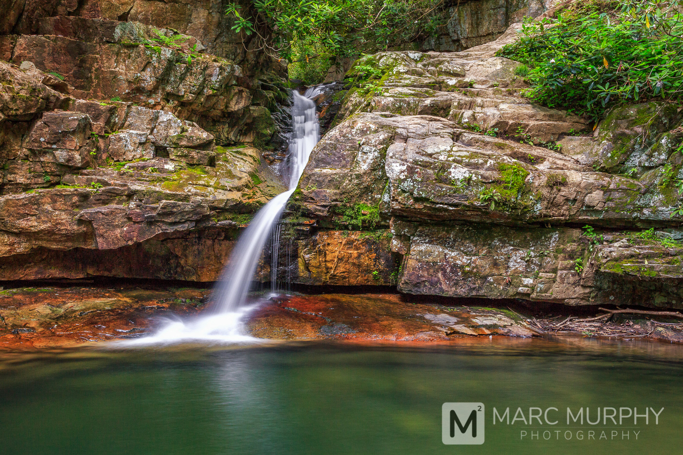 Blue Hole Falls East Tennessee Waterfall in Spring Surrounded by Rocks with Green Moss and Green Trees
