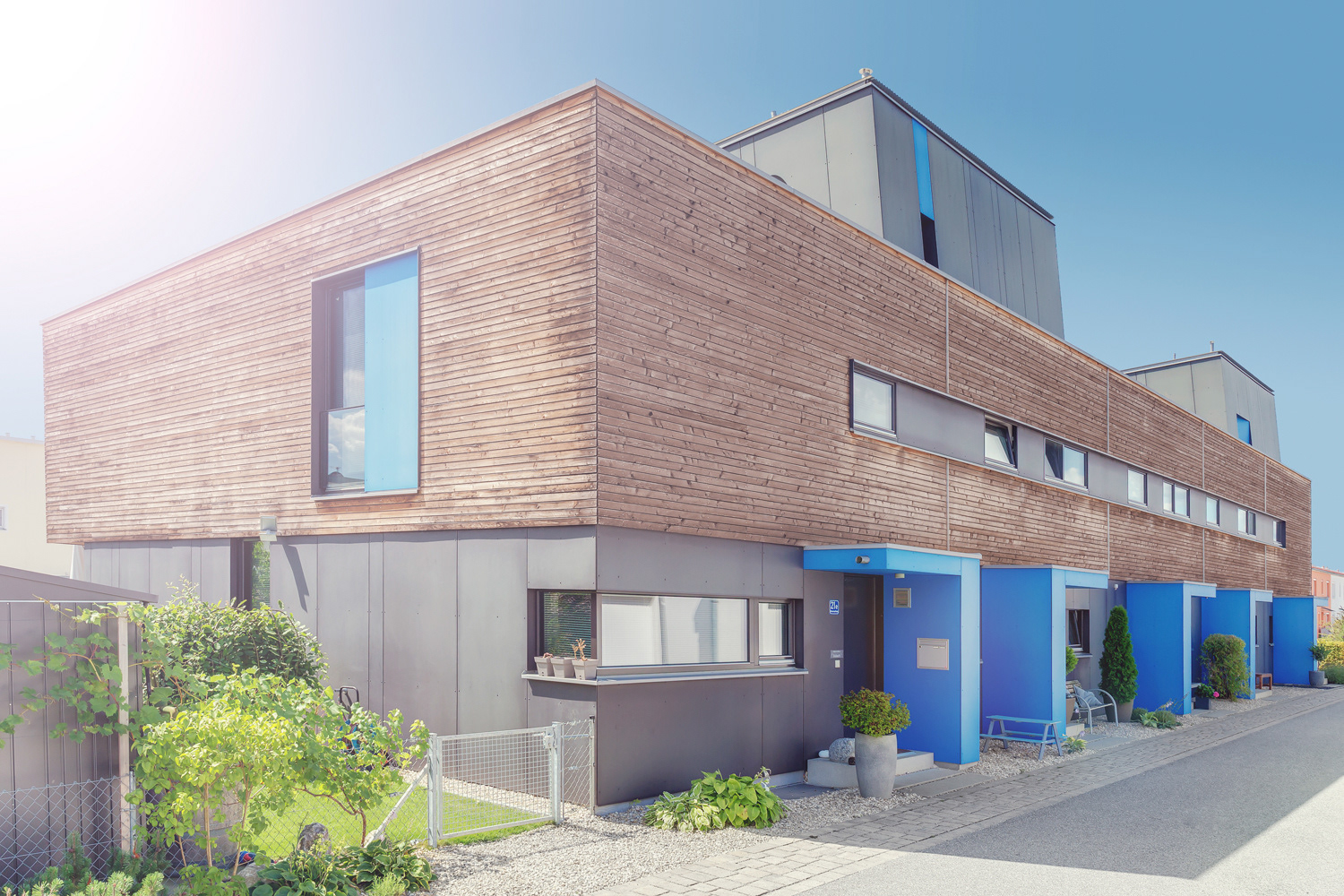 Thema: Architekturfotografie Muenchen - zweistöckiges Passivhaus mit Holzfassade und blauen Elementen an Türen und Fenstern - Fotograf: Jacob Kanzleiter