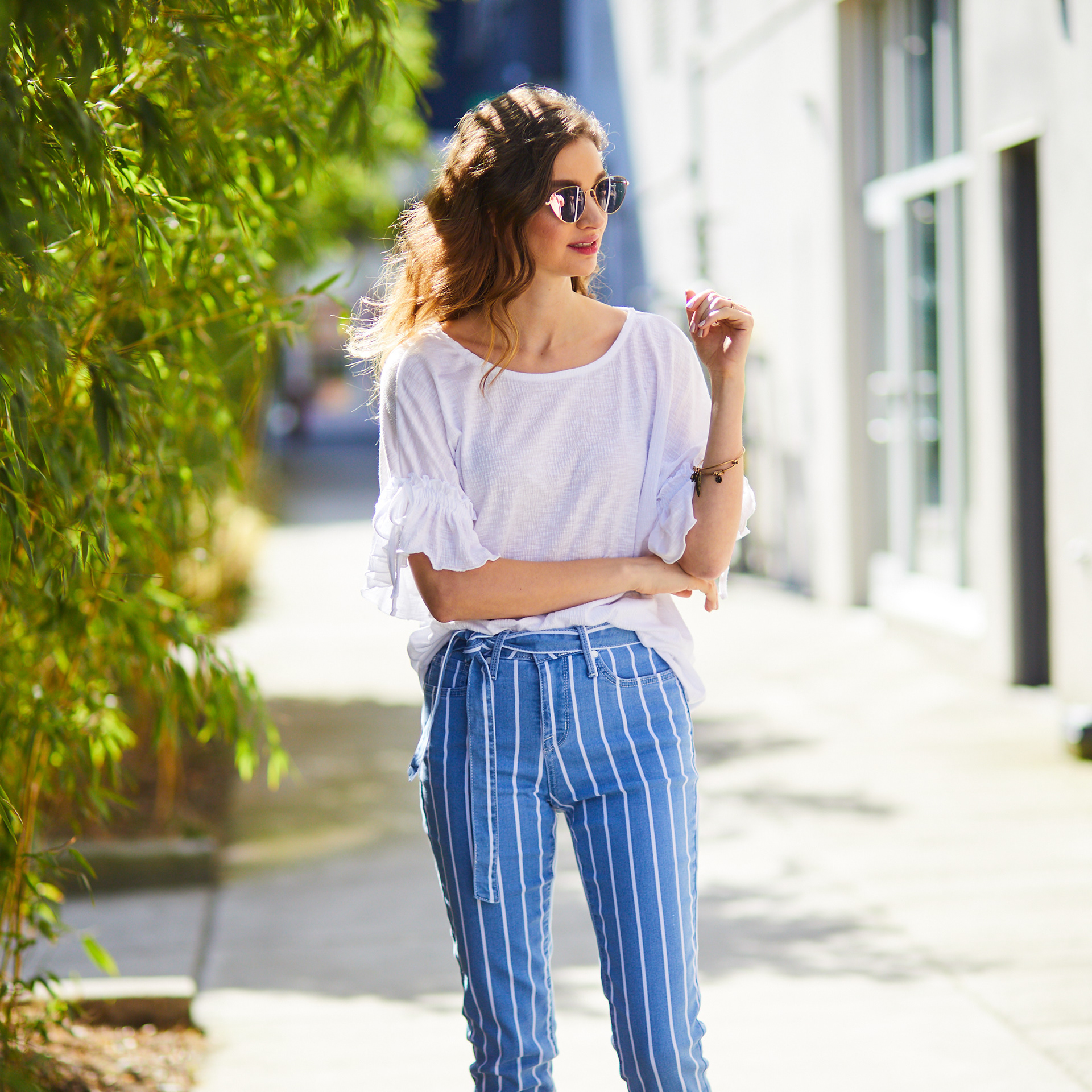 Girl modeling high waisted jeans and sunglasses in Seattle.
