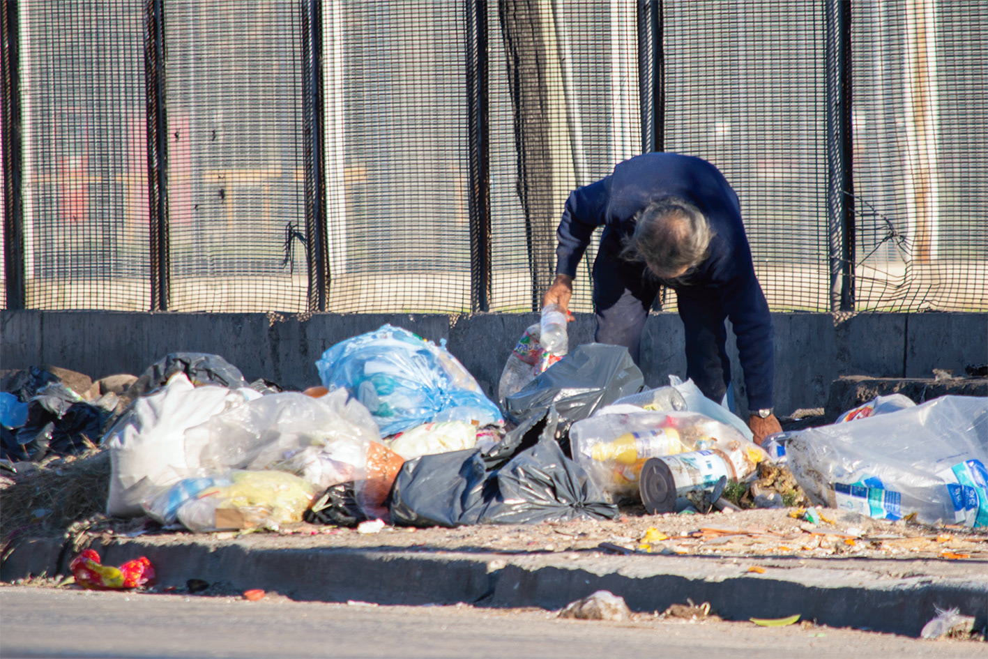 Un hombre junta botellas de plástico entre la basura. 03/08/2019 Isidro Casanova, Buenos Aires, Argentina. Foto: Luciano Cericchio/ Argra Escuela