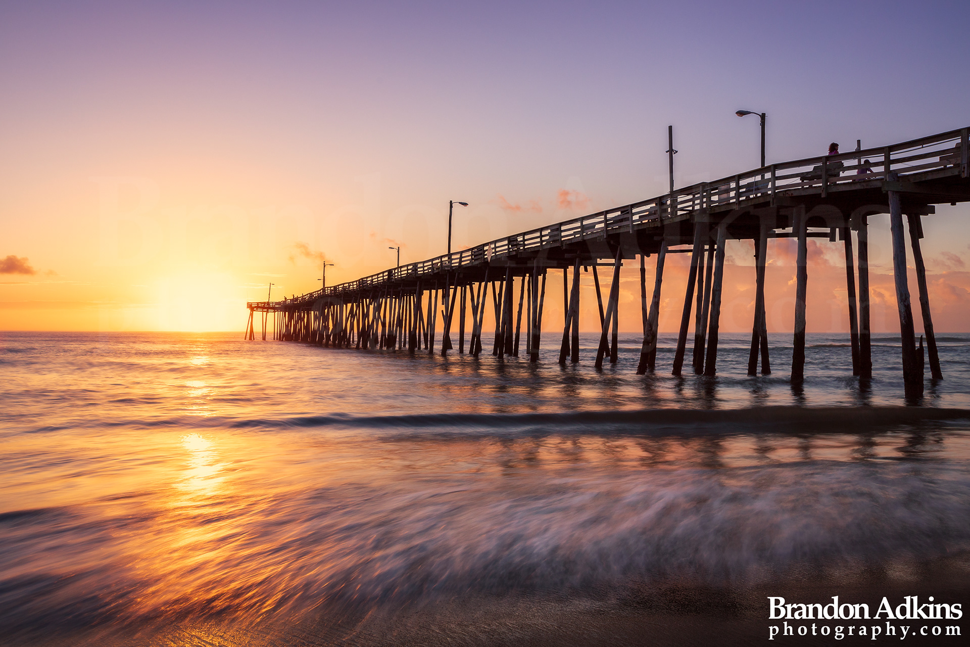 Fine art photograph of Nags Head fishing pier with sun rising over the Atlantic Ocean in the Outer Banks, North Carolina