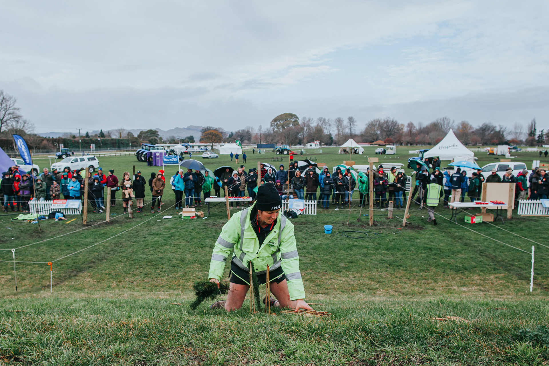 Planting trees with spectators watching on.
