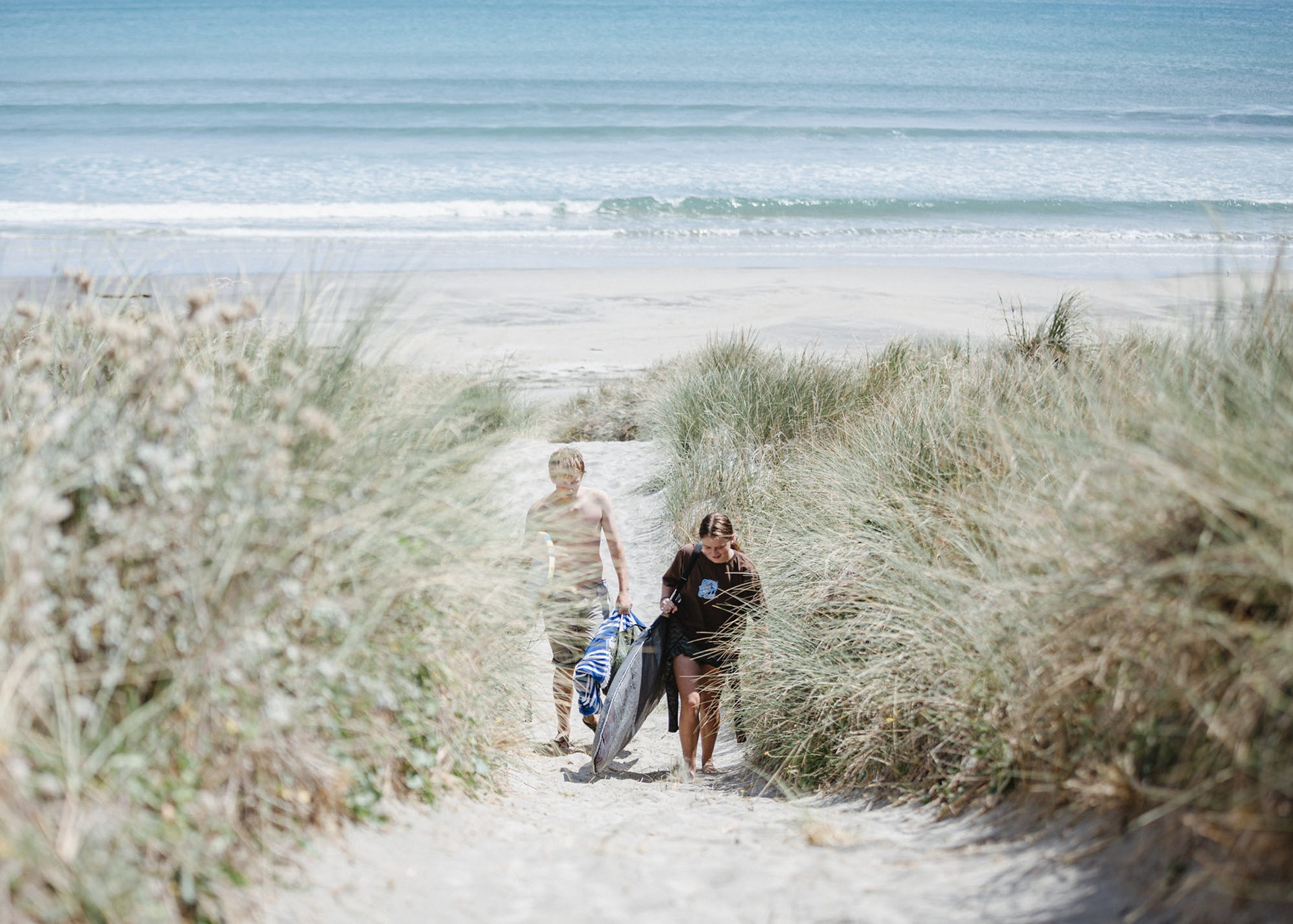 Ollie and Georgia leave the beach after a surf