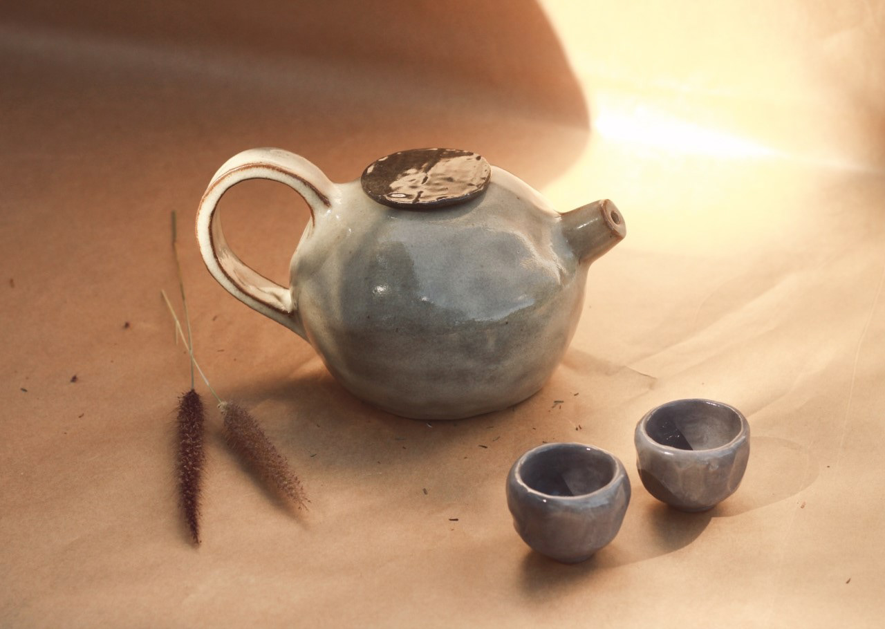 Conjunto de chá, com bule verde nublado e duas xicaras. Queimados em alta temperatura.