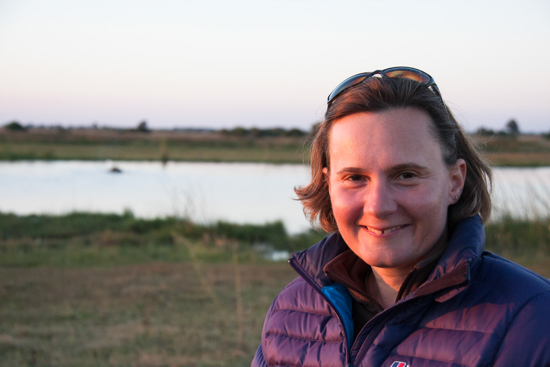 Sue enjoying a sundowner and watching hippos in the water