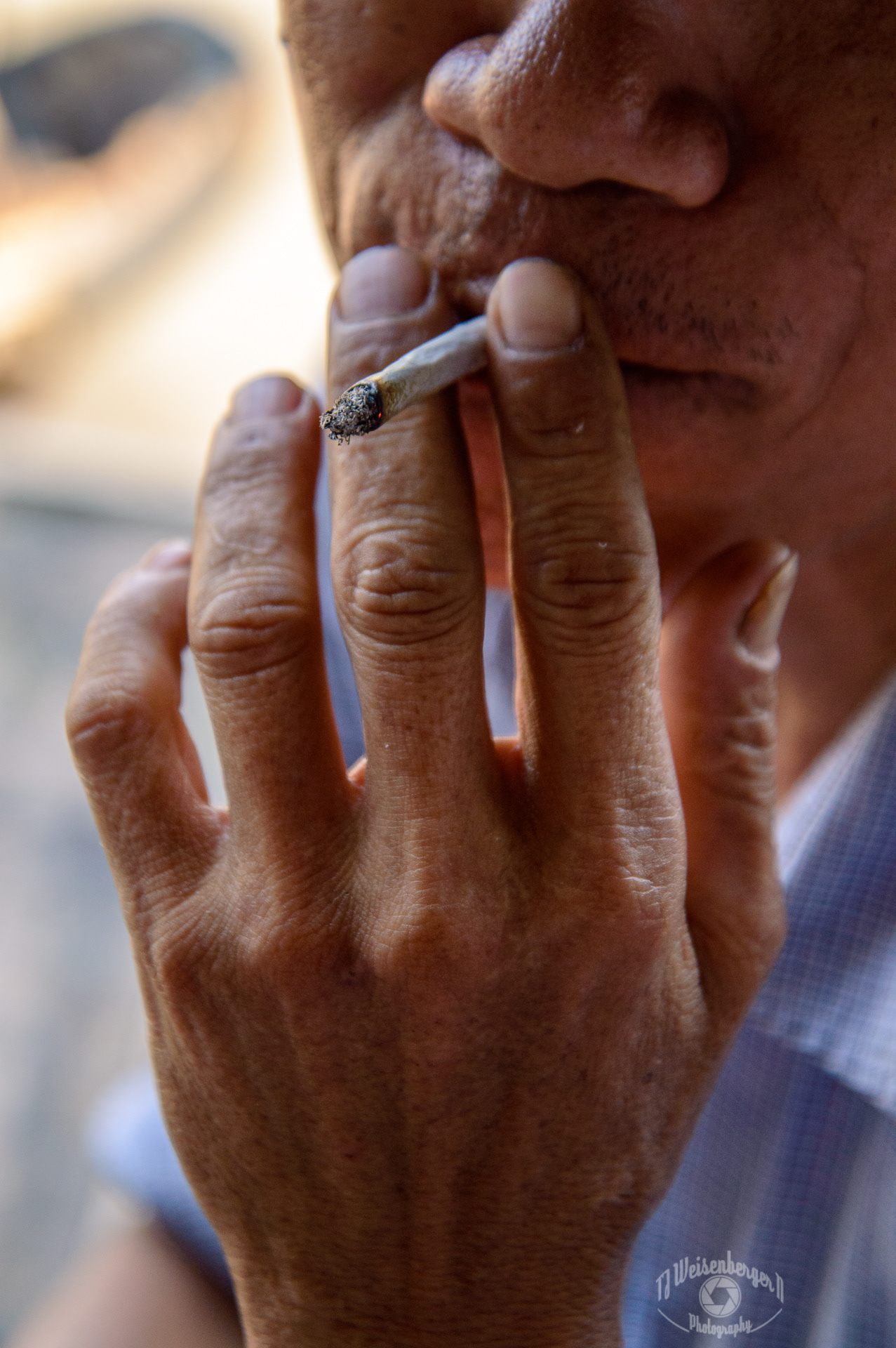 Hands Cai Rang Floating Market Boatman Smoking Handrolled Cigarette - Can Tho, Vietnam; Asia; Asian; Body Part; Cai Rang; Can Tho; Culture; Floating Market; People; Photography; Planet Earth; Southeast Asia; Spring; Summer; Sunny; Tourism; Travel; Travel Destinations; Vietnam; Working Hands; cigarette; close-up; fingers; hand; holding; market; no face; outdoors; partial face; smoking; vendor; vietnamese; workers hand; working; TJ; Weisenberger