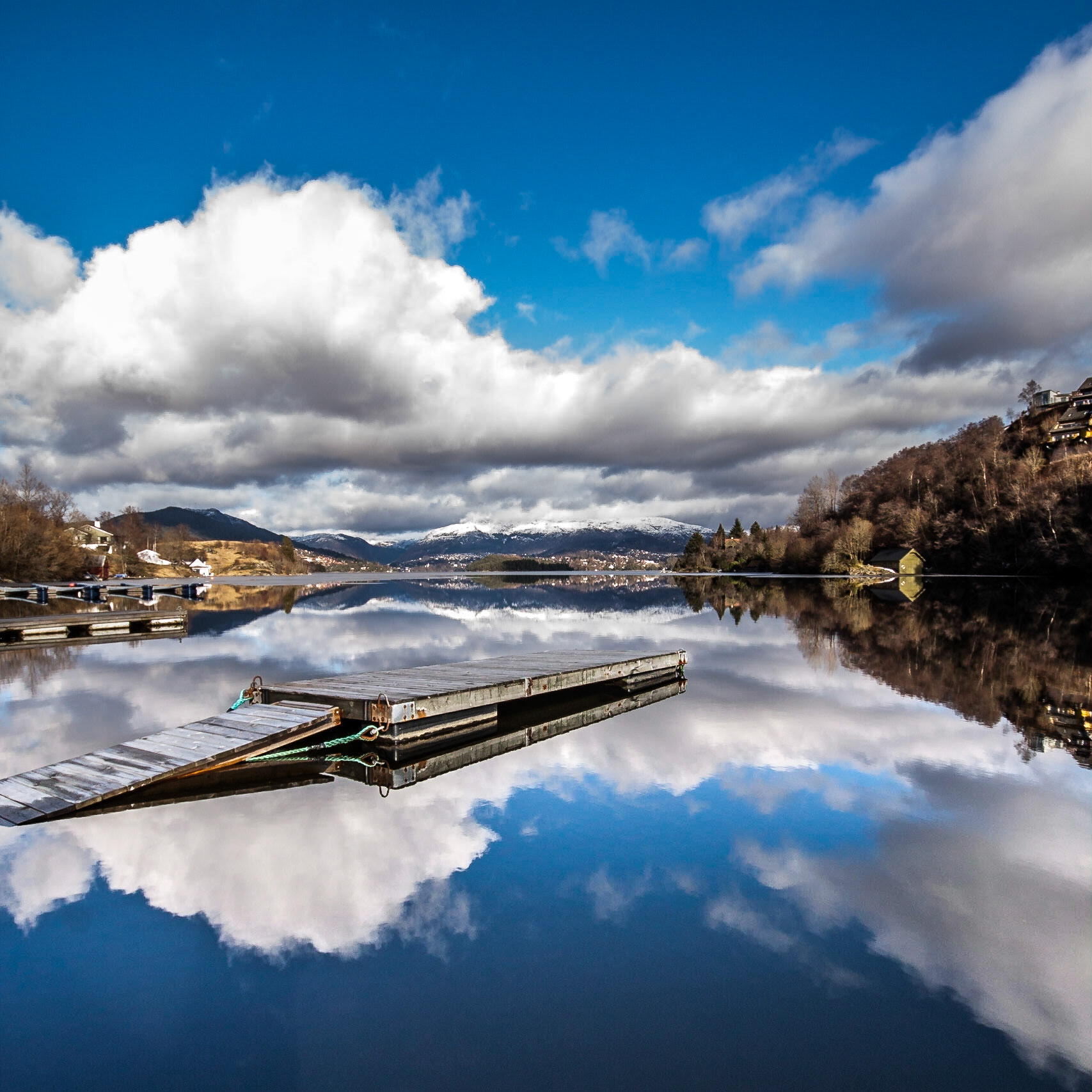 A floating dock on the calm and reflective blue water