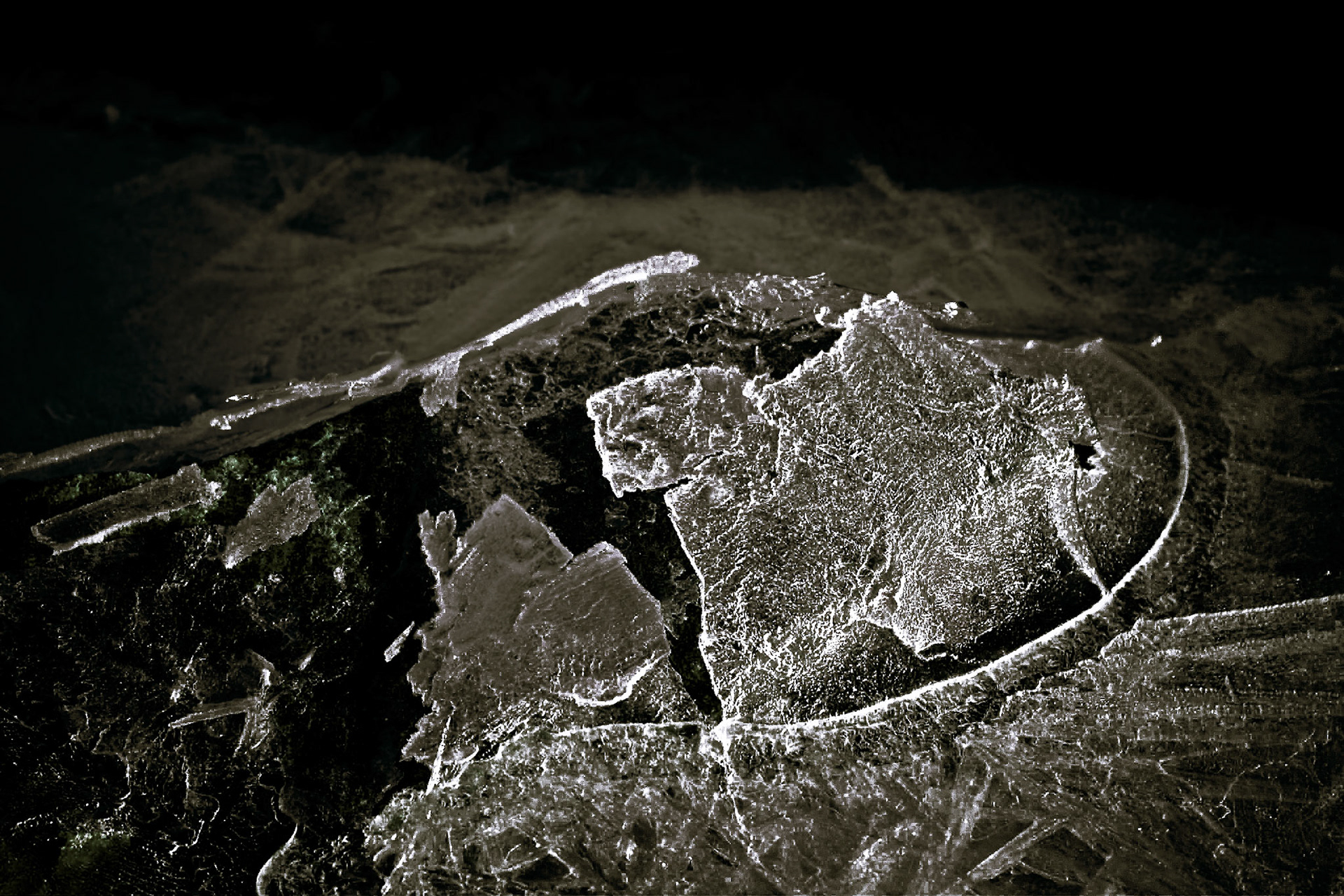 Tidal water has moved the ice so a rock broke it