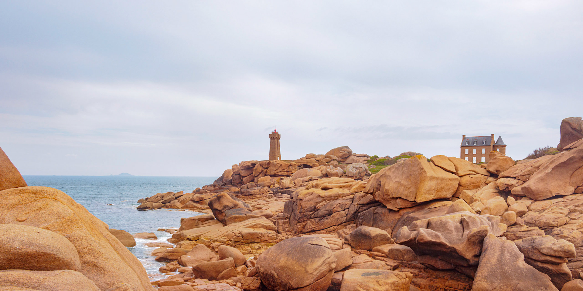 The Light House Mean Ruz in Bretagne; France, under a clouded sky. Another juxtaposition of human and natural elements, both the house and the lighthouse fit very well in the landscape.