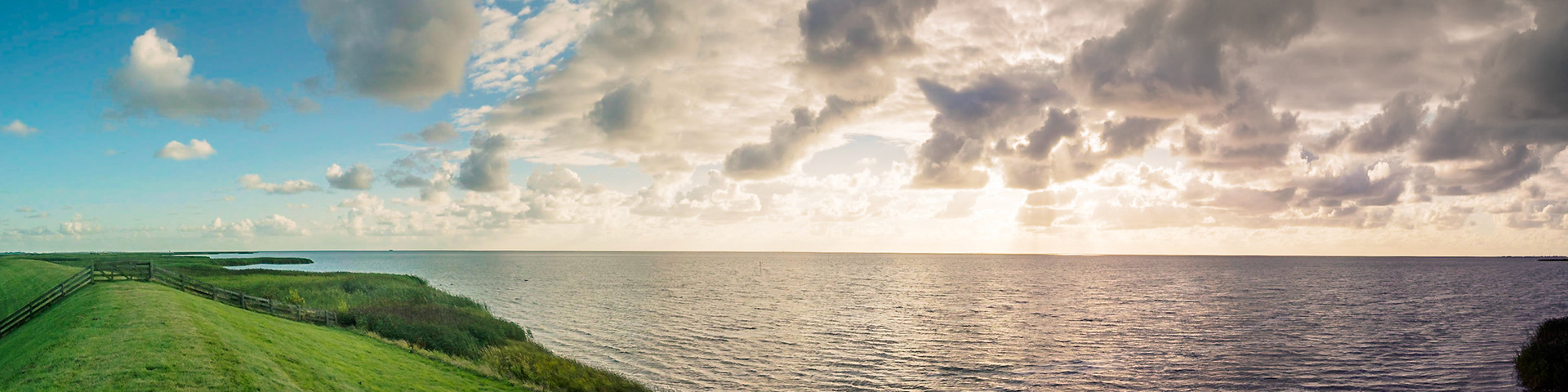 Transition from clear blue sky to ominous clouds at sunset over a lake