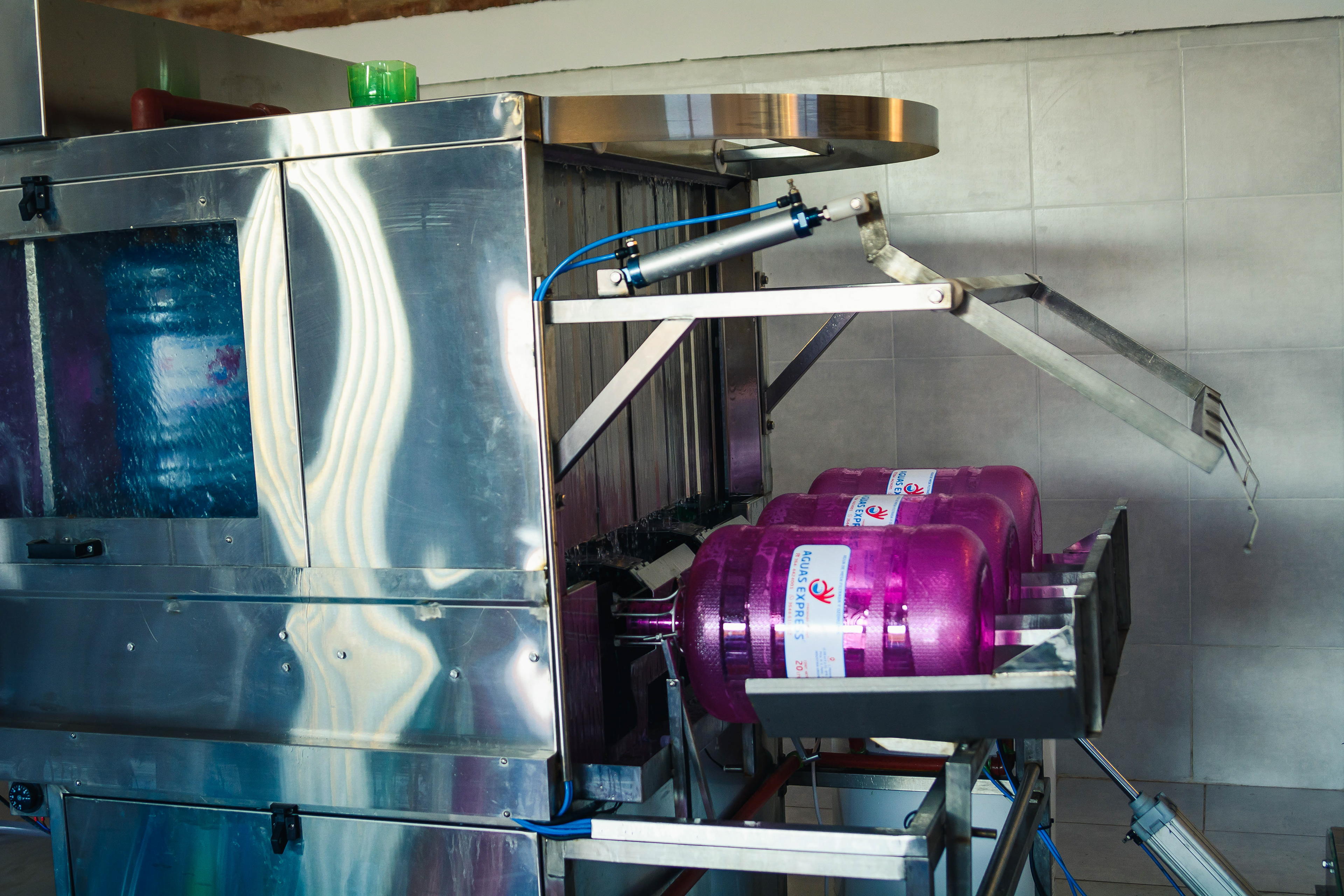 INGRESO DE LOS BIDONES A LA MÁQUINA LAVADORA Y ENVASADORA