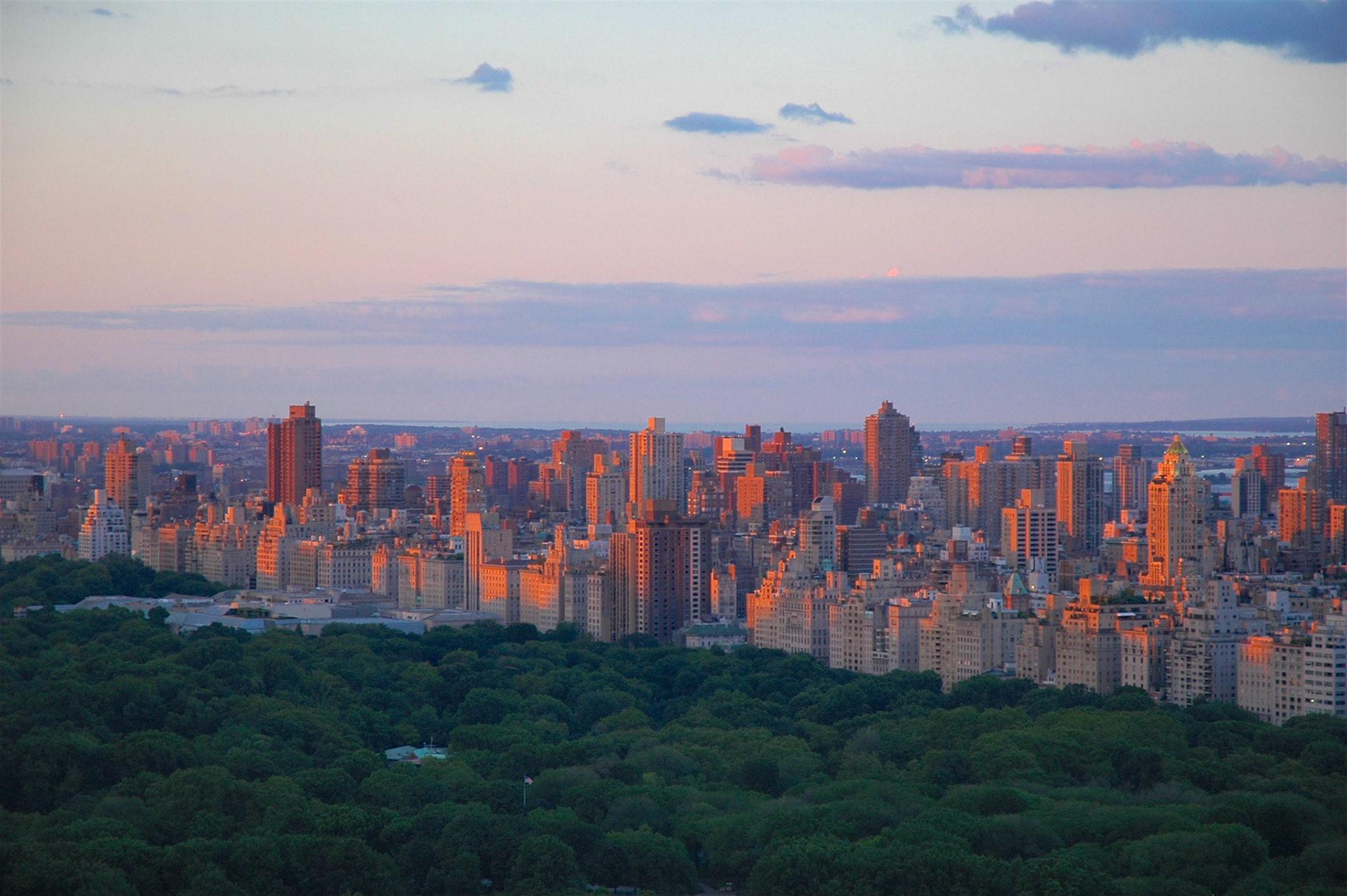The setting sun casting evening light on the buildings on the east side of Central Park