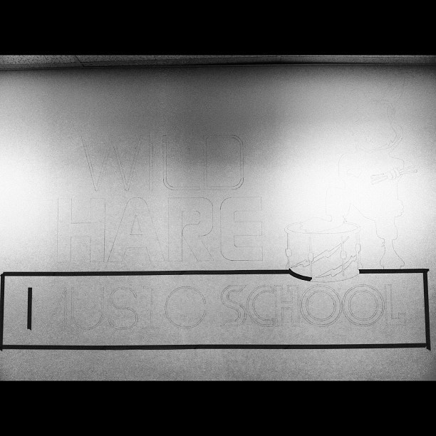 Logo being painted onto shop wall
