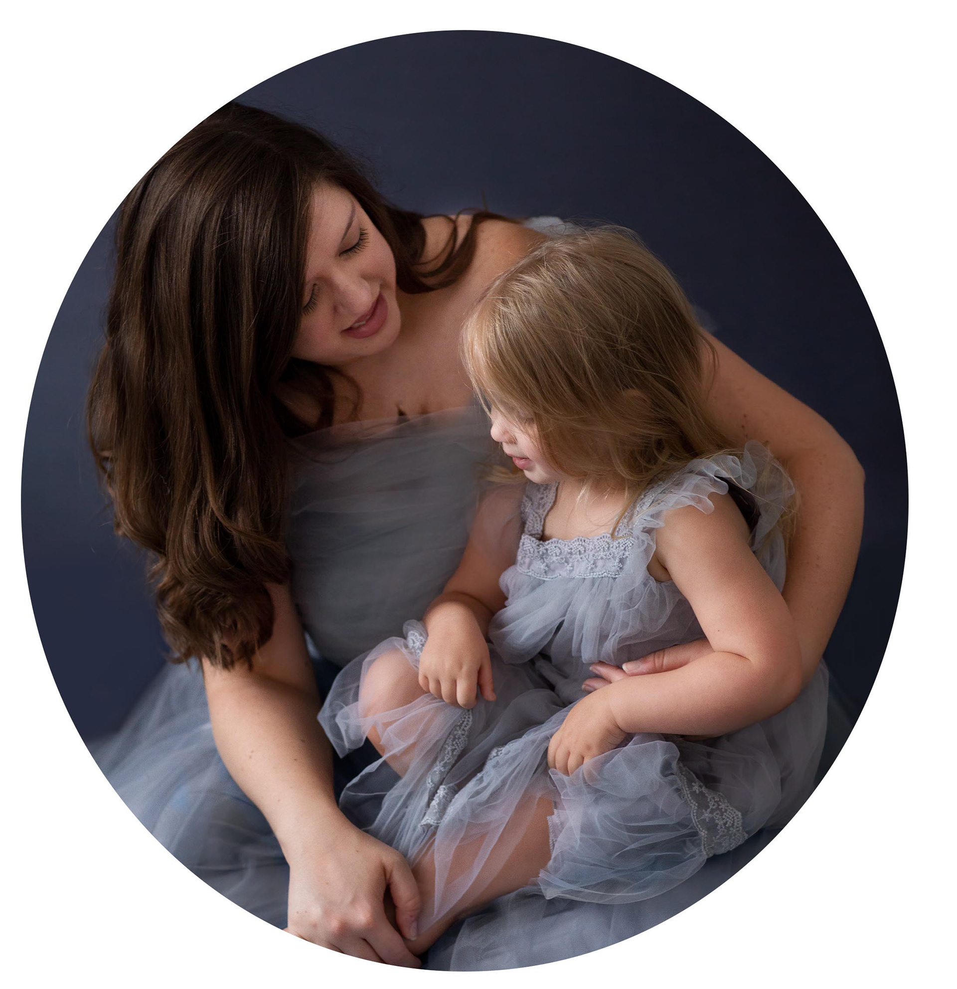 Mother with her 3 year old sitting in her lap, both of them wearing grey tulle.